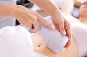 Portrait of relaxed young female client getting SMAS ultrasound face lifting massage