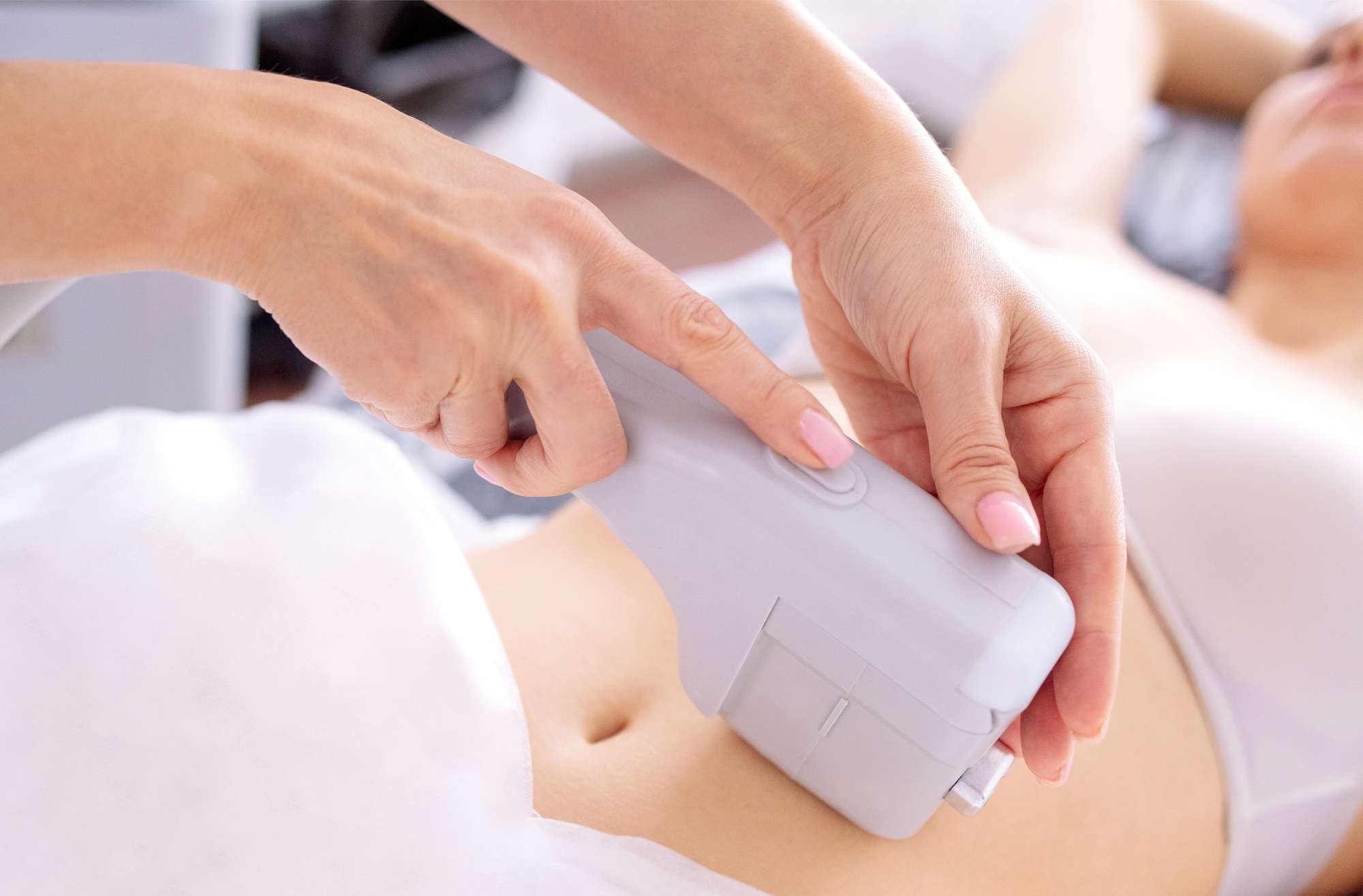 Portrait of relaxed young female client getting SMAS ultrasound face lifting massage